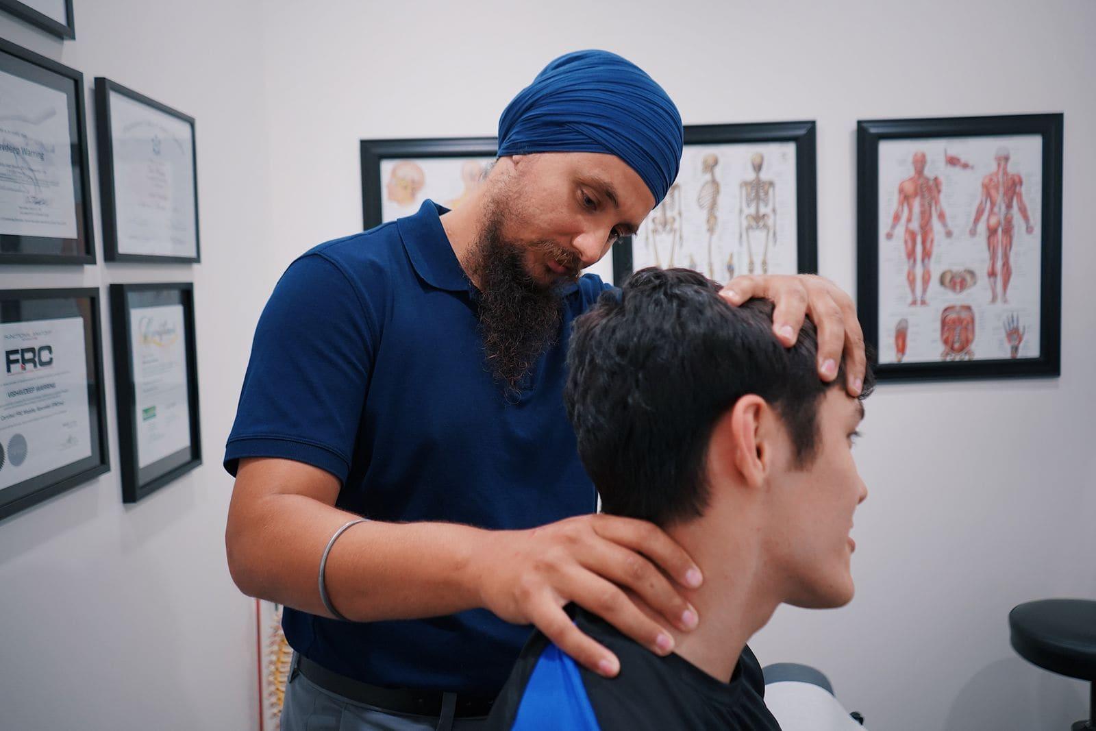 A clinician assessing a patient's neck movement in a treatment room