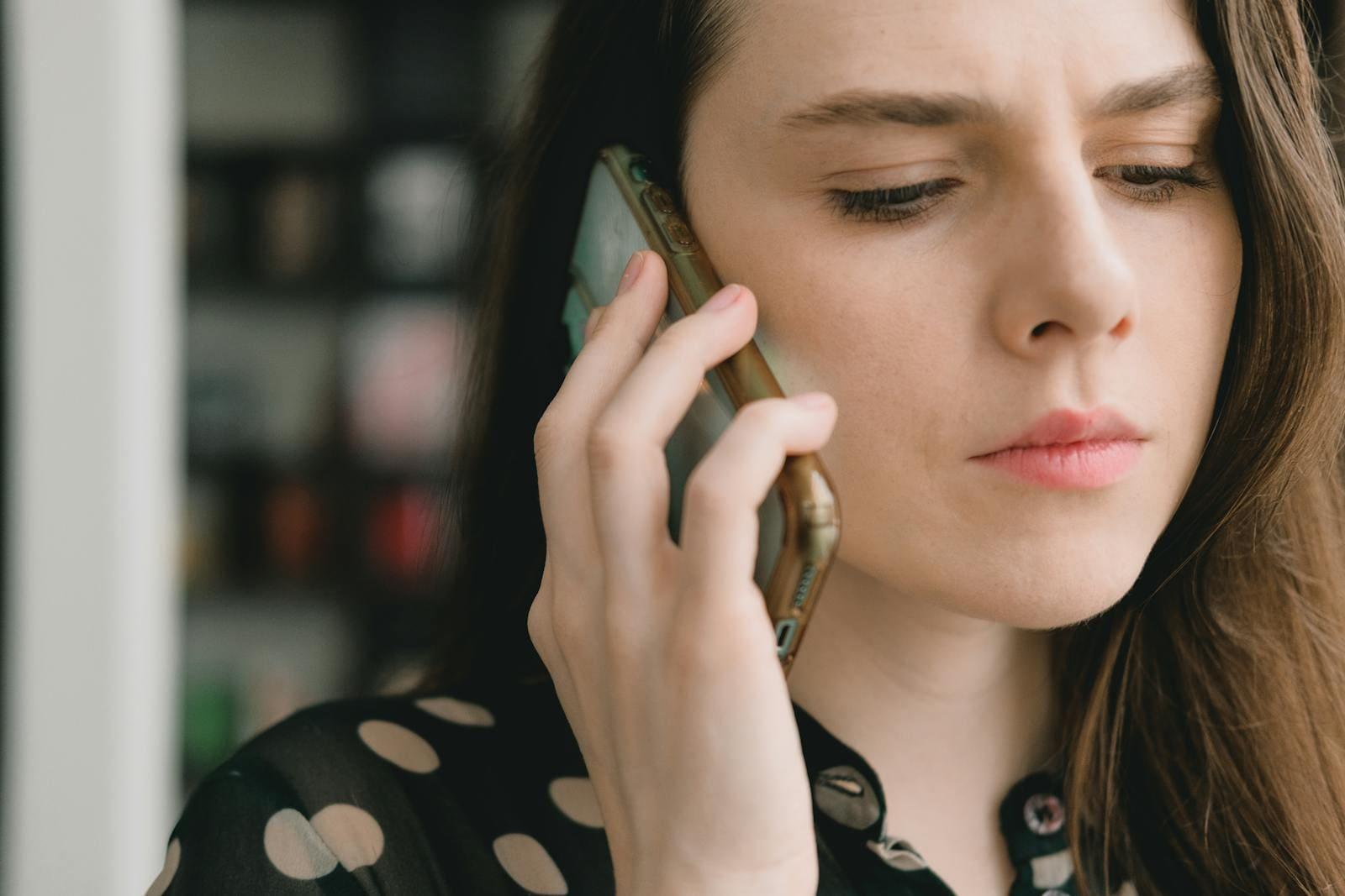 A woman on a phone call, listening intently