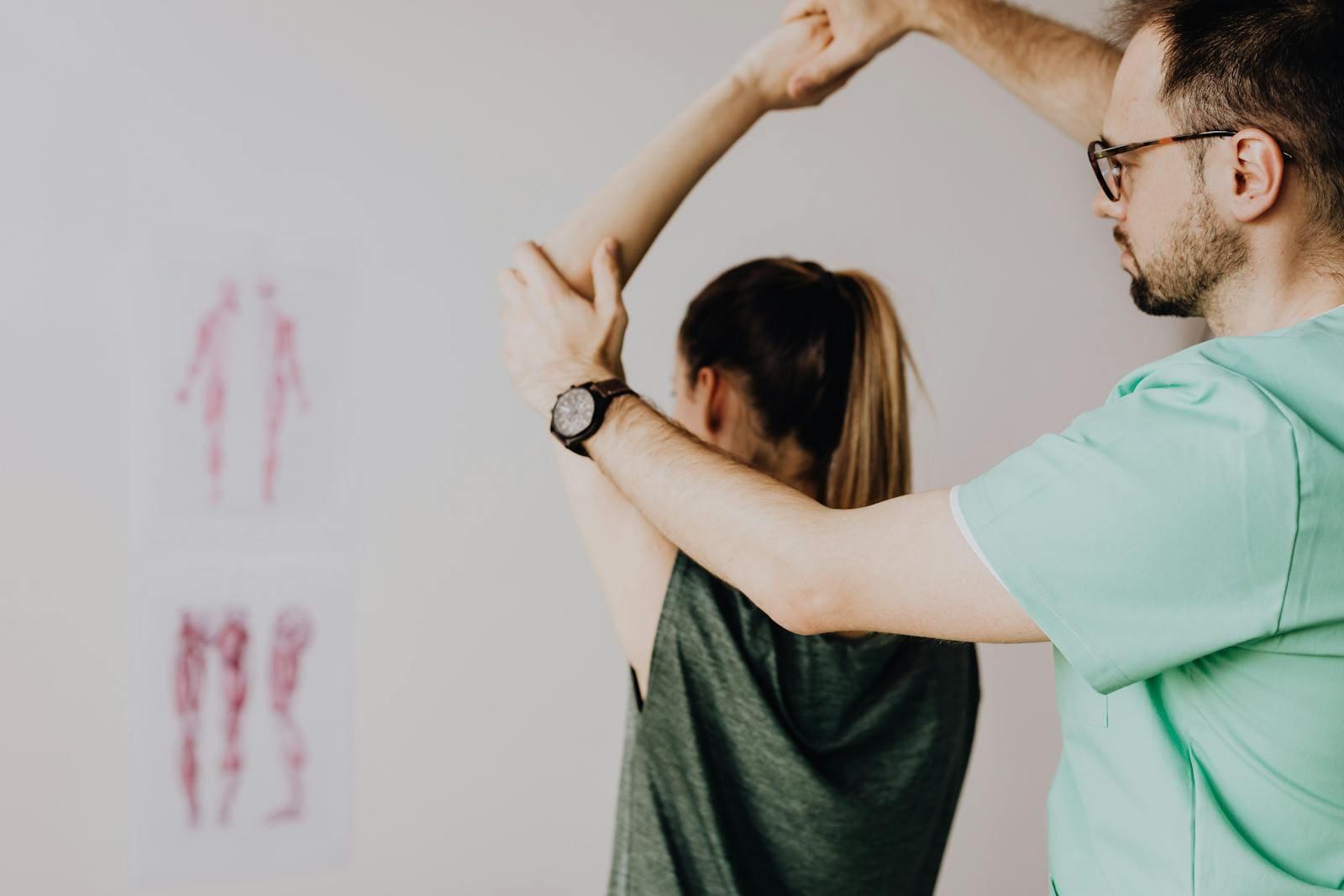 A physiotherapist taking a patient's arm through an overhead shoulder movement