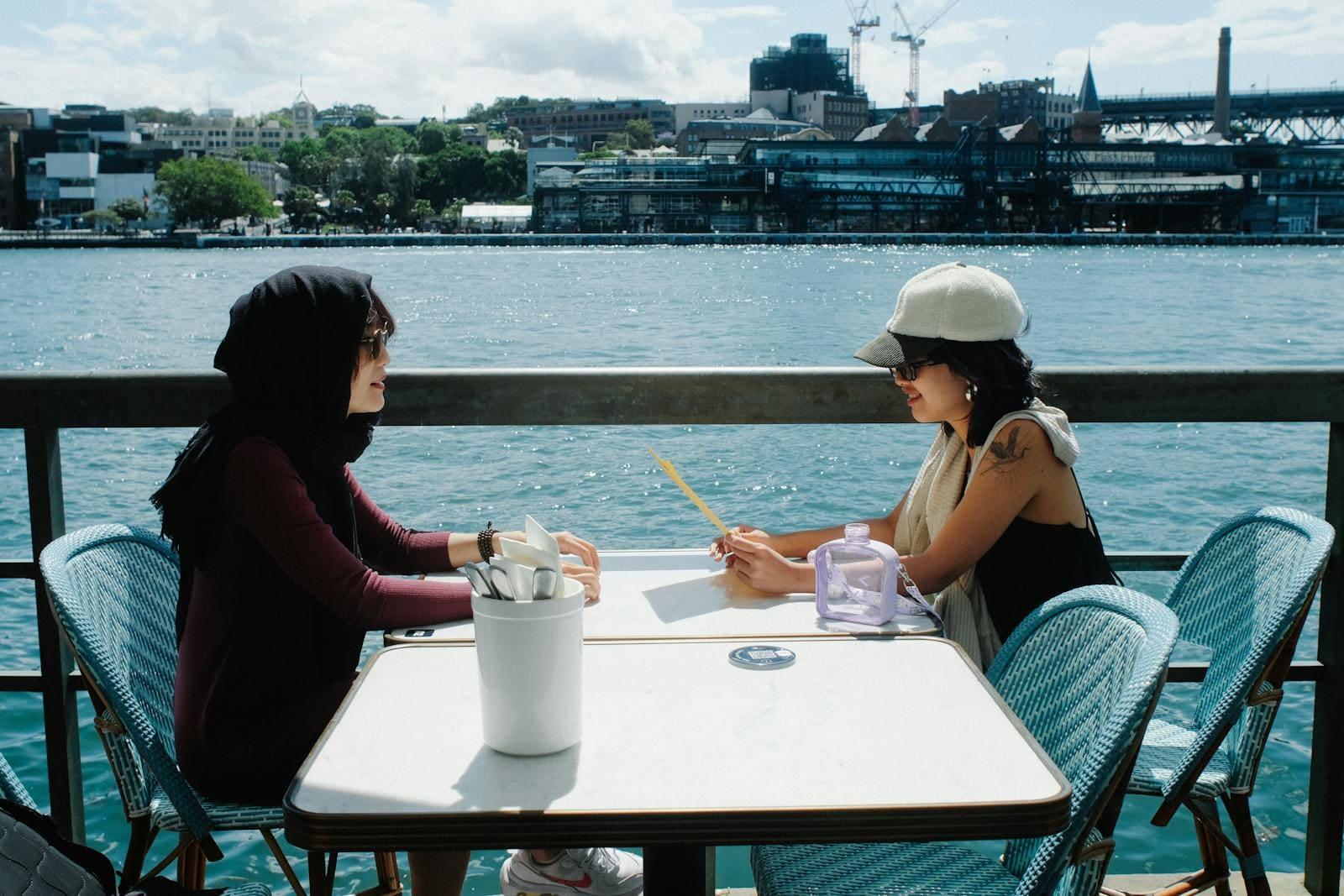Two women talking at a cafe by Sydney Harbour